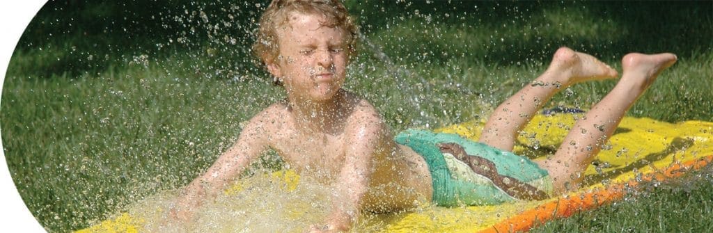 category-outdoor Outdoor and Sports - Boy outside on grass sliding on Slip N Slide Vintage